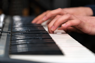 Fototapeta na wymiar Hands of a pianist close-up. Plays on the synthesizer. Selective focus