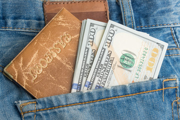 Money and passport in a denim pocket