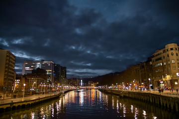 Fototapeta na wymiar Magical bridge and river illuminated at night in Bilbao. Spain