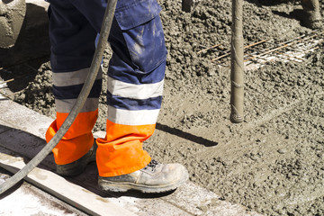 mason bricklayer workers in construction site with concrete vibrator machine