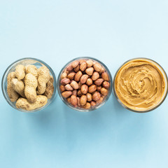 Three jars of peanut in a shell, peeled peas and vegan peanut butter. Cooking Natural Healthy Food Concept. Top view, flat lay