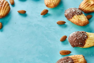 Yummy almond cookies arranged on blue background, close-up, selective focus, top view.