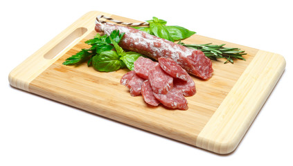 Dried sliced organic salami sausage on wooden cutting board
