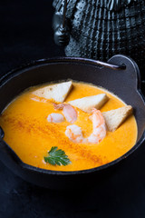 Orange asian seafood cream soup with prawns