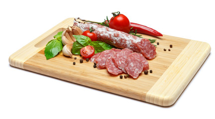 Dried sliced organic salami sausage on wooden cutting board