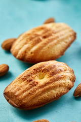 Yummy almond cookies arranged on blue background, close-up, selective focus, top view.