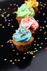 Tasty cupcakes on dark background. Birthday cupcake in rainbow colors.