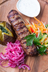 Grilled kebab served with baked potato