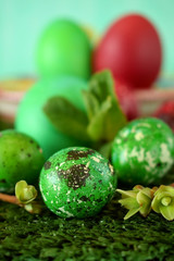 Easter coloured eggs surrounded by flowers on grass