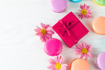 Photo of cake macarons, gift box, tea, coffee, cappuccino and flowers. Sweet romantic food macaroon concept. Morning breakfast and presents. Valentine's day concept.