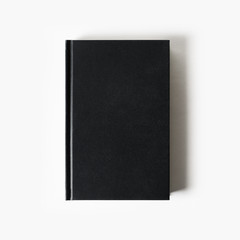 Blank black booklet. Vertical book cover on white paper background. Flat lay.