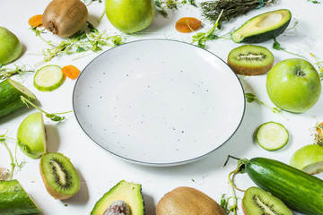 Ingredients for cooking smoothie. Organic green vegetables and fruits on wooden white rustic background.