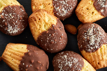 Freshly baked almond cookies on stone board over wooden background, top view, selective focus.