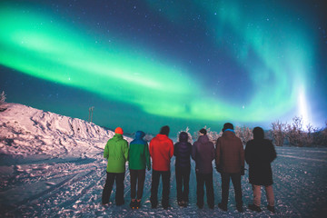 Beautiful picture of massive multicolored green vibrant Aurora Borealis, also known as Northern Lights in the night sky over winter Lapland landscape, Norway, Scandinavia