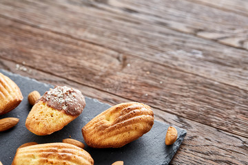 Freshly baked almond cookies on stone board over wooden background, top view, selective focus.