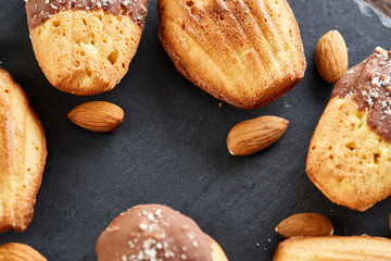 Freshly baked almond cookies on stone board over wooden background, top view, selective focus.