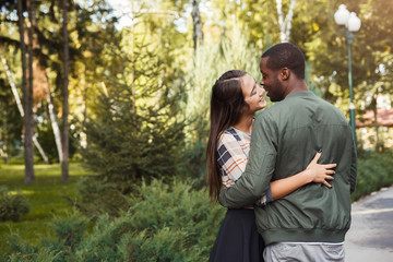 Happy couple hugging in park copy space
