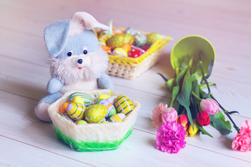 Basket full of Easter eggs with flowers and bunny