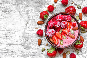 Smoothie bowl with red berries - strawberry and frozen raspberry, nuts and seeds. healthy breakfast