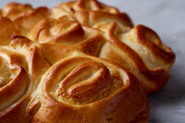 Homemade rose bread on white textured background, close-up, shallow depth of field, top view