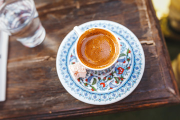 Turkish hot coffee in traditional painted cup top view on the table in cafe