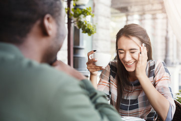 Young bored girl drinking coffee on date at a cafe