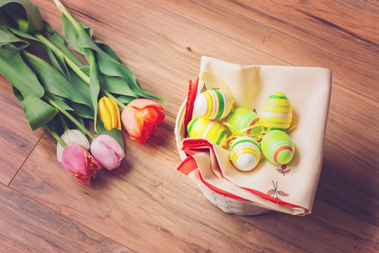 Bunch of tulips with Easter eggs in a basket