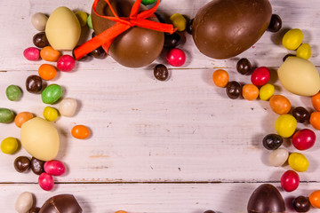 Chocolate easter eggs on a white wooden table. Top view