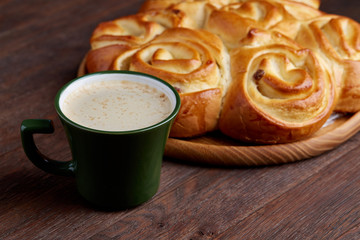 Homemade rose bread, cup of coffee, anise and cinnamon on vintage background, close-up, selective focus