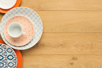 Empty vintage plates and coffee cup on natural wood, top view