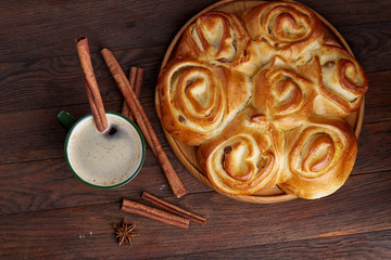 Homemade rose bread, cup of coffee, anise and cinnamon on vintage background, close-up, selective focus