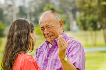 Close up of father really mad with her daughter and shooting a facepalm at outdoors