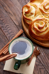 Homemade rose bread, cup of coffee, anise and cinnamon on vintage background, close-up, selective focus