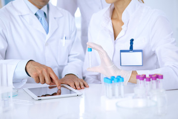 Fototapeta premium Team of scientific researchers in laboratory studying substances or blood sample. New vaccine for pharmacology industry is s almost ready. Medicine and science concept