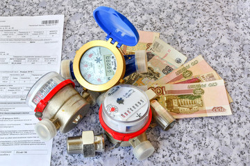 Three counters of water, invoice for payment and money close up.