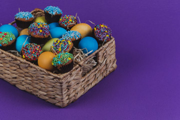 Easter eggs and Easter cupcakes in a basket. 