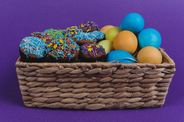 Easter eggs and Easter cupcakes in a basket. 
