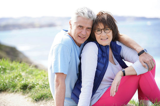 Portrait of cheerful 60-year-old couple relaxing by the sea