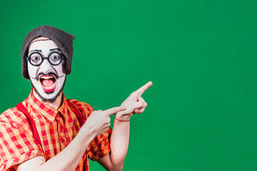 cheerful mime posing near a green background