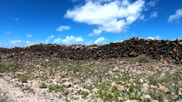 Vulkanlandschaft mit alter Steinmauer, Fahraufnahme, Fuerteventura, Kanaren, 4K