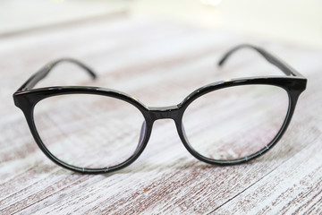 Women's fashionable eyeglass frame on white wooden background