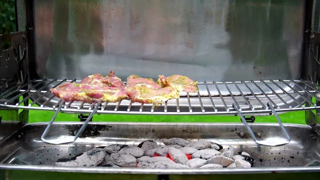 Fleisch auf den Grill legen, Holzkohlegrill