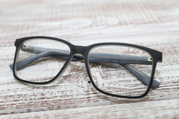 Fashionable men's eyeglass frame on white wooden background