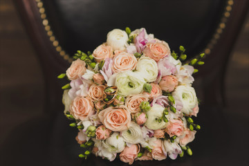 Bridal morning details. Wedding bouquet of orange, beige and pink flowers with succulent