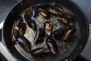 Stewed mussels in wine in a frying pan