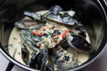 Stewed mussels with vegetables in a saucepan