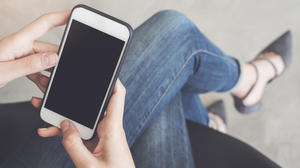 Woman using mobile phone sitting on a chair crossed legs