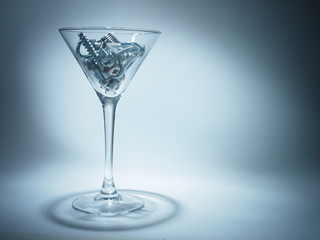 shiny metal bolts and hardware in a glass