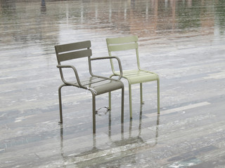 Fototapeta premium rainy day: two chairs on a square