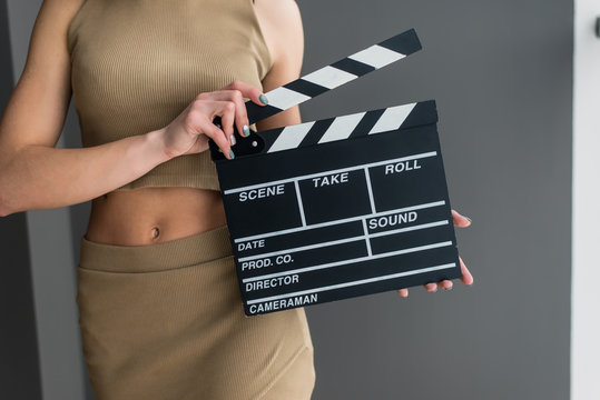 Attractive girl with a clapperboard in her arms
